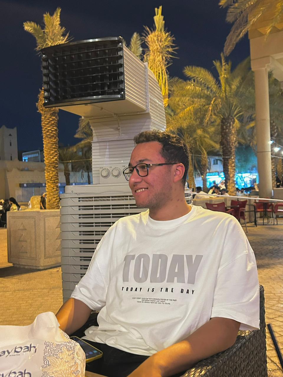 Hamdy sitting outdoors at night